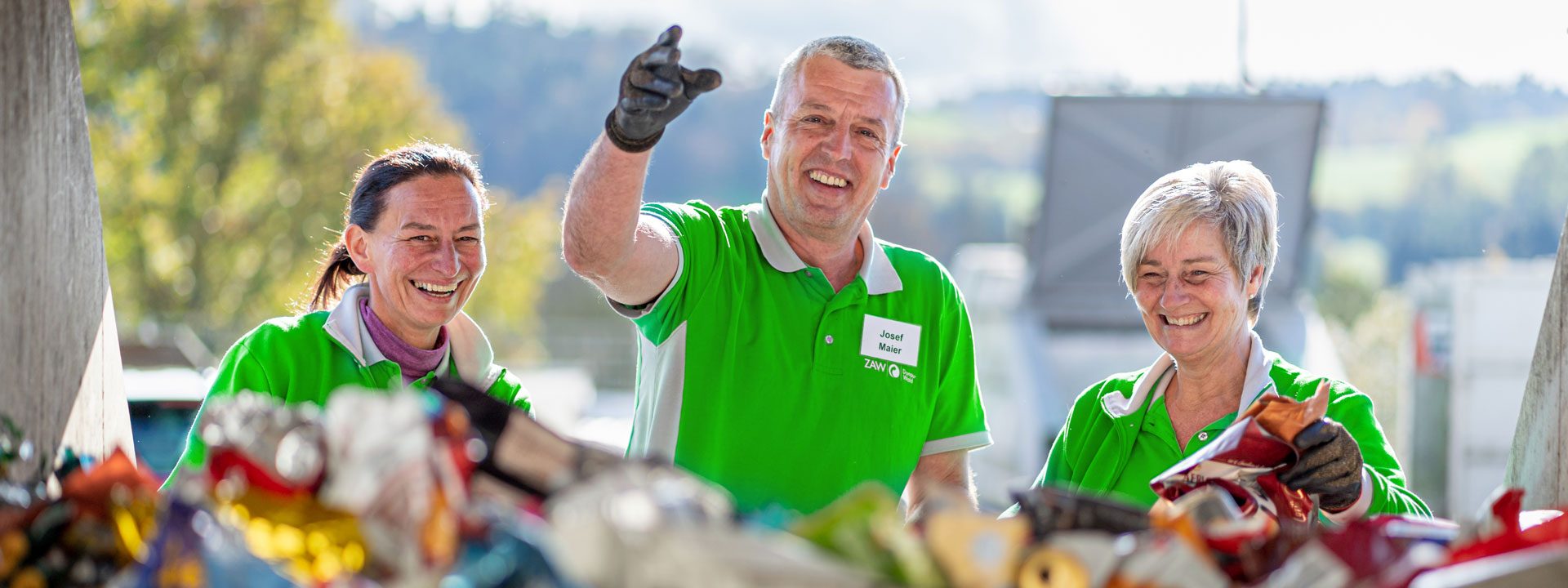 Bannerbild, Drei Mitarbeiter eines Recyclinghofes bei der Arbeit